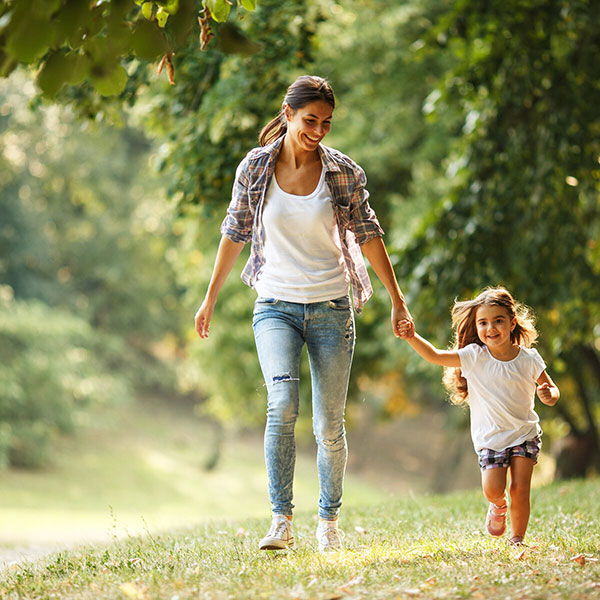 Woman holding hands and walking with daughter