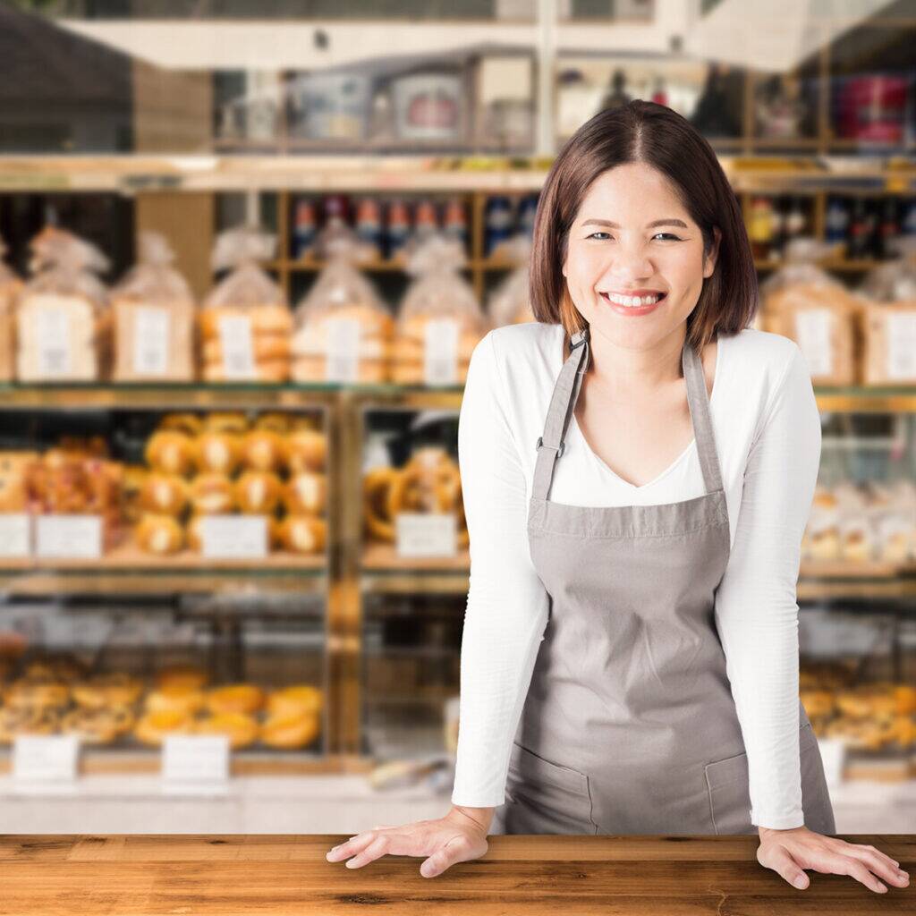 Woman standing behind counter at bakery